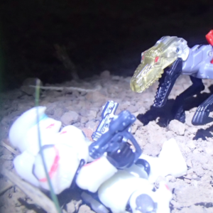 A robotic velociraptor bears its jaws towards a space soldier in a sleek helmet on their back with two pistols in each hand.