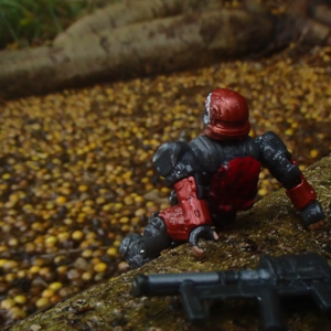 Armored space soldier sitting on a tree root overlooking a pond filled with yellow and brown seed pods on a rainy day.